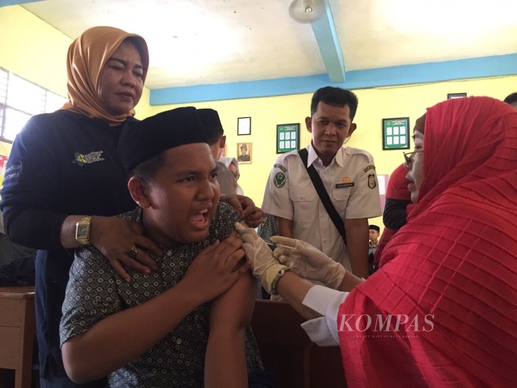 Siswa MTs Negeri Model Makassar, Sulawesi Selatan, diimunisasi di ruang kelas, Rabu (1/8/2018). Sekolah ini juga menjadi tempat pencanangan gerakan imunisasi campak-rubela fase kedua nasional.