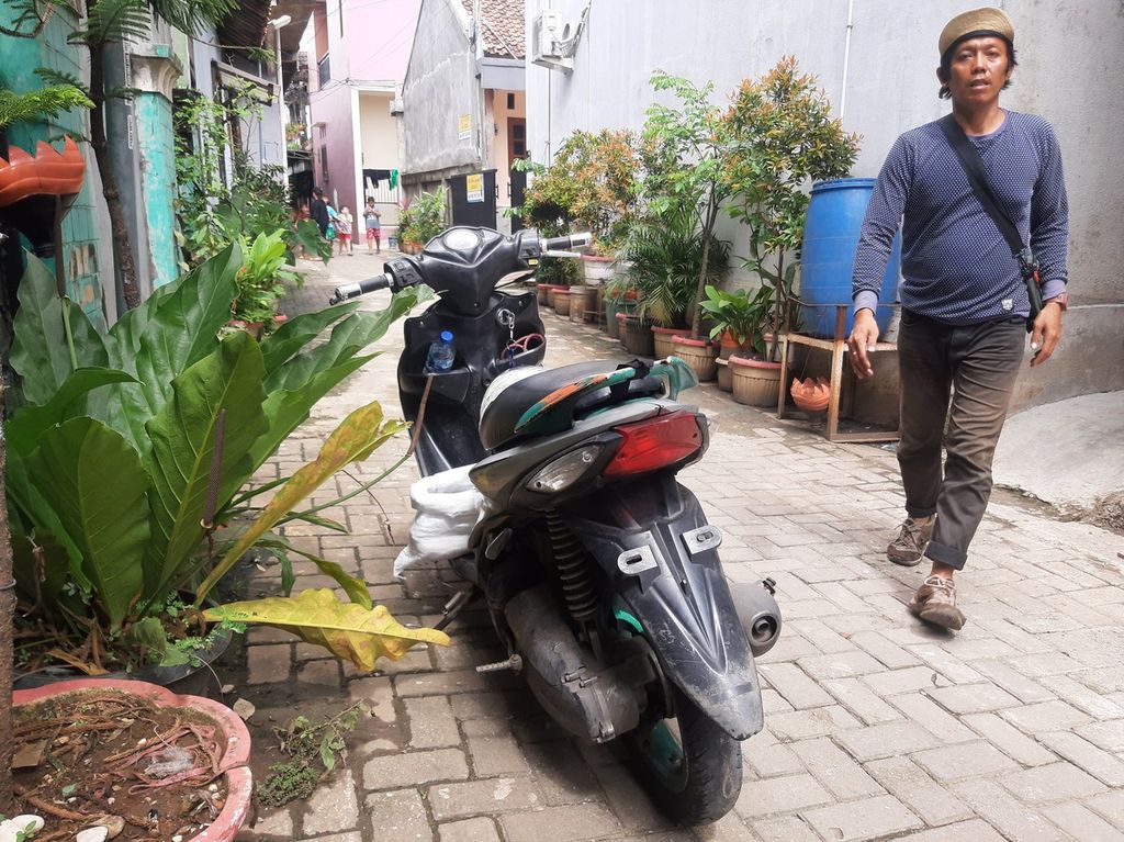 Damiri (42), kurir ekspedisi, menyerahkan barang kepada pelanggan di kawasan Kelurahan Gaga, Tangerang, Banten, Kamis (9/3/2023).