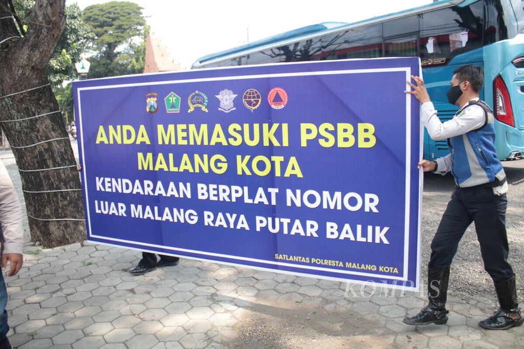 Sabtu (16/5/2020), petugas menyiapkan papan informasi terkait PSBB Malang Raya. PSBB Malang Raya dilaksanakan pada 17 Mei 2020 hingga 30 Mei 2020.