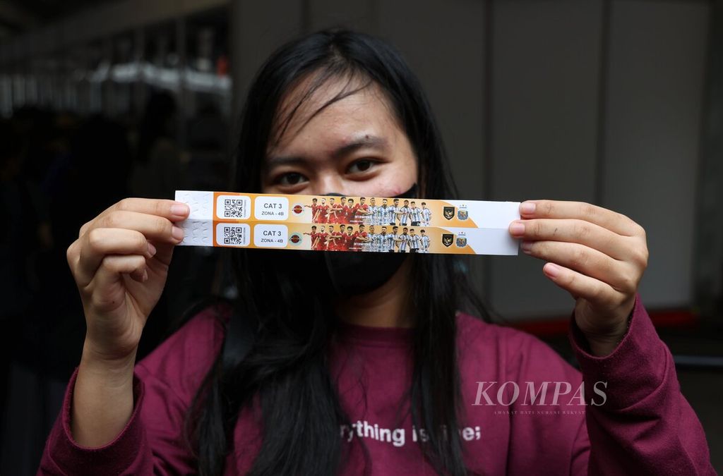 Salah seorang calon penonton menunjukkan tiket yang diperolehnya setelah mengantre panjang untuk menukarkan tiket pertandingan uji coba timnas Indonesia melawan Argentina di Wisma Serbaguna, Senayan, Jakarta, Sabtu (17/6/2023). 