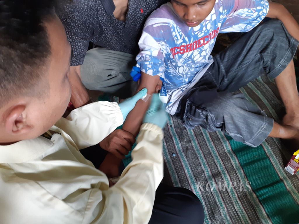 Petugas kesehatan mengambil sampel darah Arya (12), anak penderita gangguan mental, di Desa Cinangka, Kecamatan Ciampea, Kabupaten Bogor, Jawa Barat, Kamis (20/9/2018).