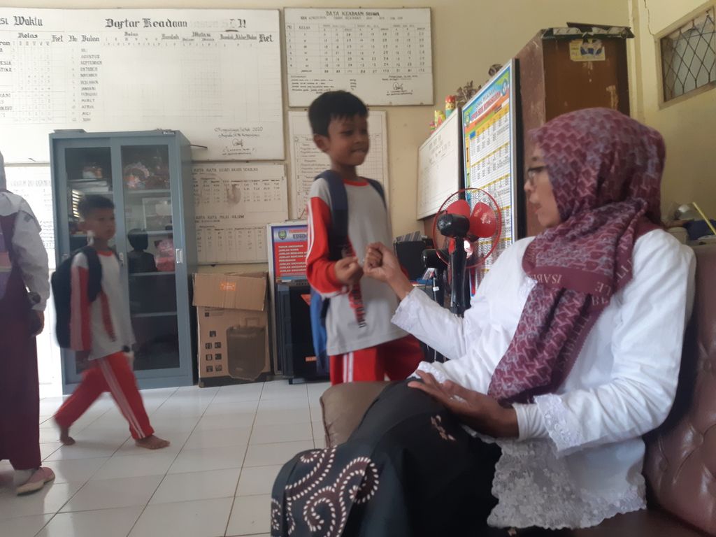 Srihani (41) bersalaman dengan sejumlah siswa di salah satu sekolah dasar negeri di Kecamatan Widasari, Kabupaten Indramayu, Jawa Barat, Selasa (22/11/2022). Srihani merupakan guru honorer yang lulus seleksi pegawai pemerintah dengan perjanjian kerja atau PPPK tahun 2021. Namun, hingga kini ia belum mendapatkan formasi penempatan.