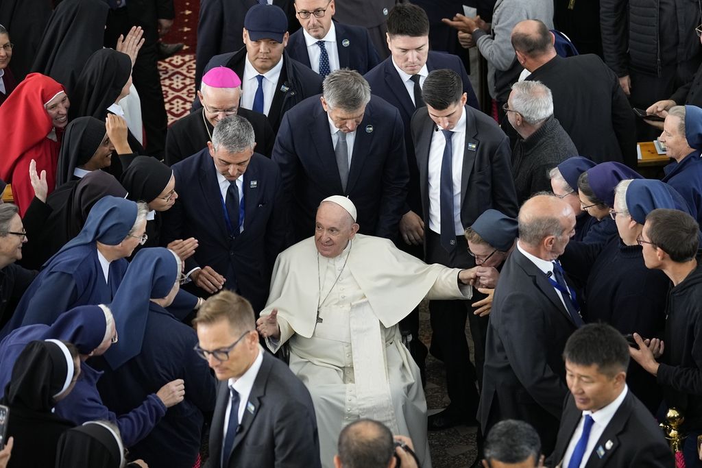 Paus Fransiskus tersenyum saat menerima warga yang berusaha mendekatinya pada akhir pertemuan di katedral di Nur-Sultan, Kazakhstan, Kamis (15/9/2022). 