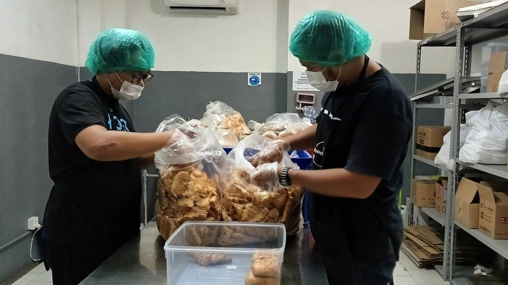 Kukuh Napaki (28) dan Sofyan Setyadi (32) dari Foodcycle Indonesia di gudang penyimpanan di Matraman, Jakarta Timur, Jumat (10/11/2023), saat memilah roti yang akan didistribusikan kepada warga.