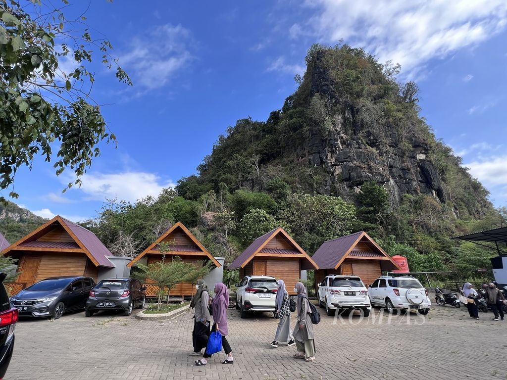 Wisatawan berjalan di depan jejeran penginapan dengan latar belakang bukit karst di obyek wisata Rammang, Rammang, Maros, Sulawesi Selatan, Sabtu (3/6/2023). Kawasan ini masuk dalam Taman Bumi Global Maros-Pangkep.