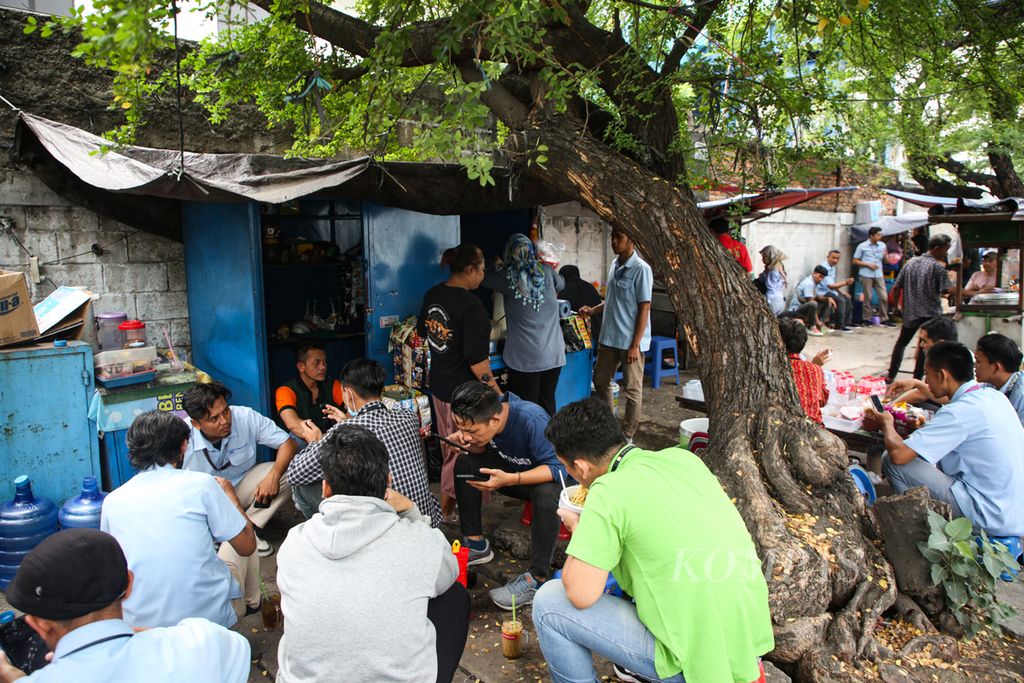 Buruh menikmati makan siang di lapak pedagang kaki lima yang berada di luar area pabrik di kawasan Karawaci, Kota Tangerang, Banten, Rabu (22/11/2023). Kenaikan upah minimum provinsi 2024 berkisar 1,2 persen hingga 7,5 persen atau Rp 35.750 sampai dengan Rp 223.280.  