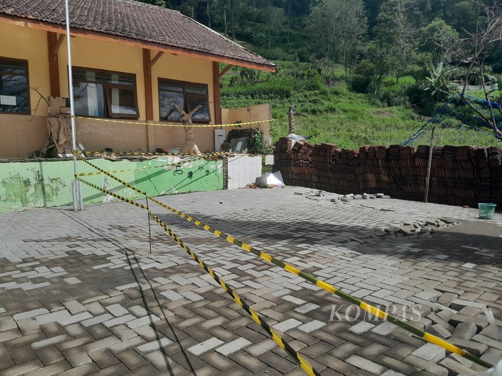 Tali plastik terbentang di halaman SD-SMP Satu Atap Baru di Dusun Brau, Desa Gunungsari, Batu, Jawa Timur, untuk membatasi agar orang tidak masuk ke area yang terdapat retakan akibat tanah bergerak. Foto diabadikan Minggu (17/3/2024).