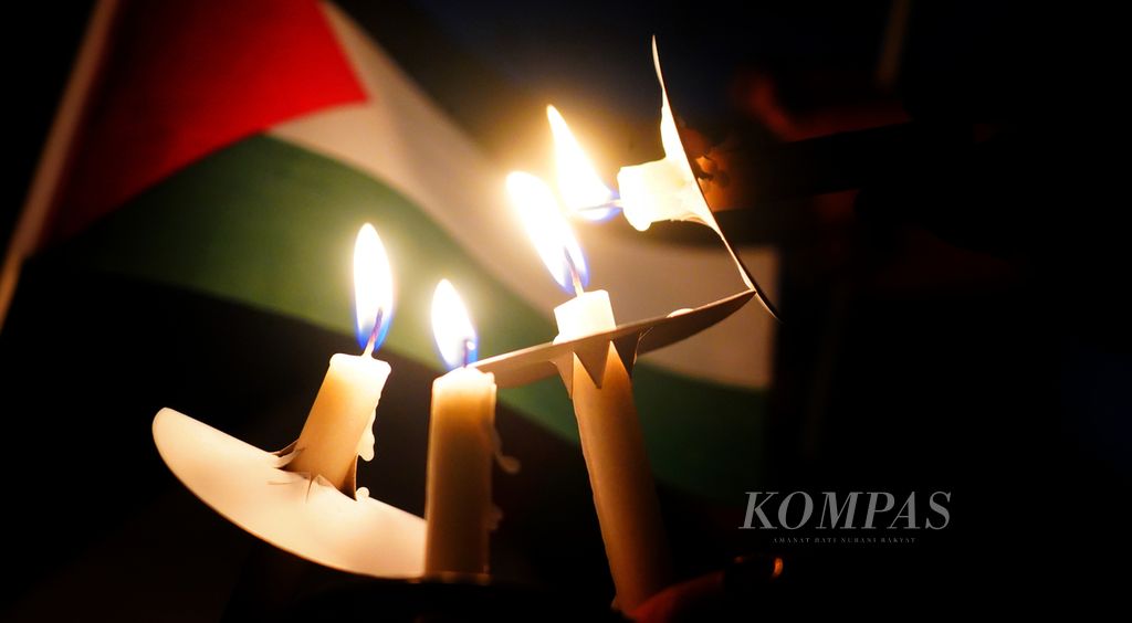 Sejumlah anak muda lintas keyakinan menyalakan lilin pada Aksi Solidaritas dan Keprihatinan atas Tragedi Kemanusiaan di Palestina di Kedutaan Besar Palestina, Jakarta, Kamis (2/11/2023) malam. 