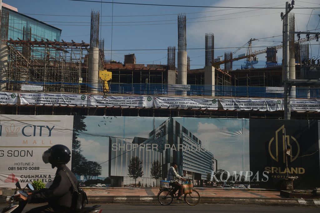 Warga melintasi sebuah proyek pembangunan apartemen yang diliburkan hampir sepekan lebih Kota Semarang, Jawa Tengah, Selasa (10/5/2022). Sebagian besar proyek pembangunan infrastruktur masih ditinggalkan para pekerjanya pulang kampung. 