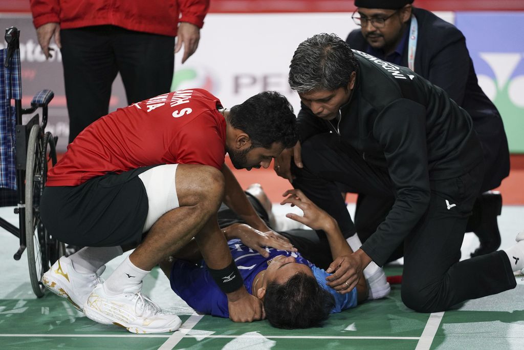 Pemain tunggal putra India, H.S. Prannoy (kiri), melihat kondisi Christian Adinata (tengah), pemain Indonesia yang terbaring akibat cedera pada semifinal turnamen Malaysia Masters 2023 di Arena Axiata, Kuala Lumpur, Malaysia, Sabtu (27/5/2023).