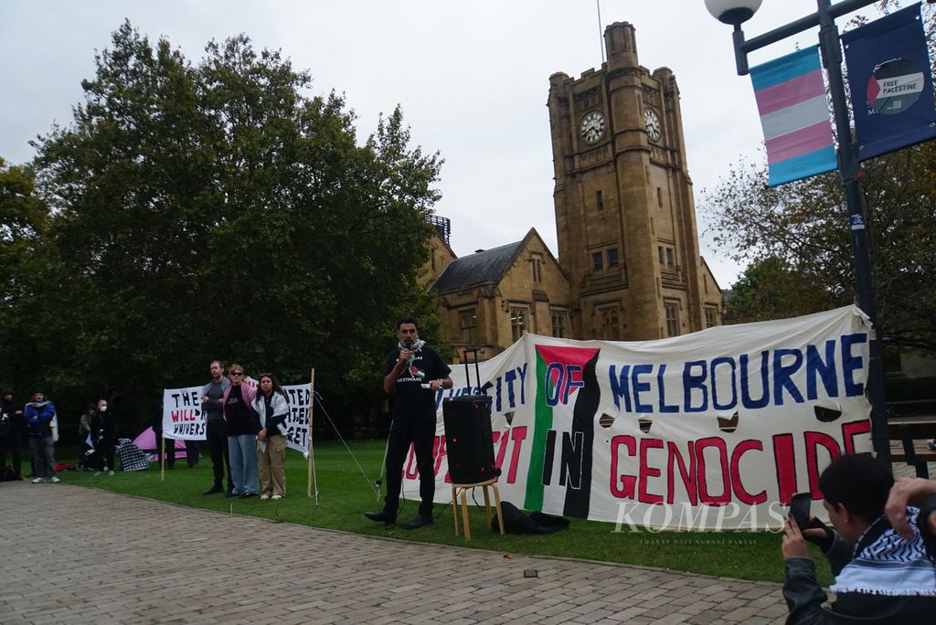 Seorang aktivis berorasi dalam gelaran protes di kampus Parkville Universitas Melbourn di Melbourne, Australia, Senin (29/4/2024), untuk meminta penghentian kerja sama dengan beberapa perusahaan yang memasok senjata ke Israel. 