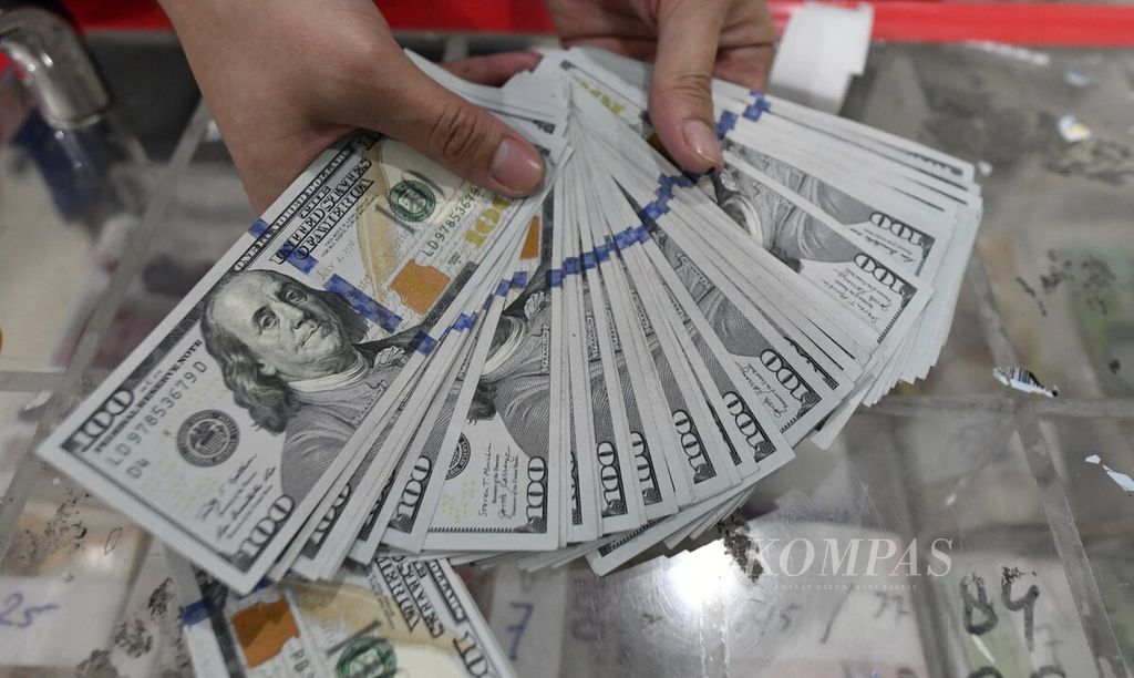 Petugas menunjukkan mata uang dollar AS di sentra kas Bank Mandiri, Jakarta, Selasa (5/4/2022). 