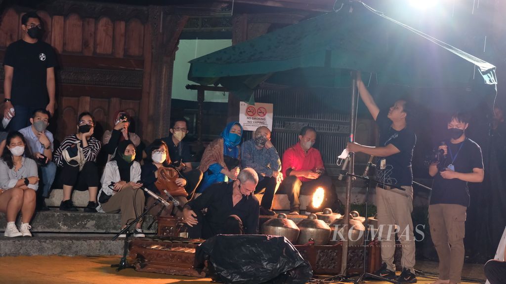 Hujan turun saat pertunjukan berjudul <i>Legenda Godogan: Kungkum Kodok</i> dipentaskan di Bentara Budaya Jakarta, Jakarta, Sabtu (27/8/2022) malam. Panitia berusaha memayungi para penampil. Adapun sejumlah penonton berteduh di pinggir area pentas. Pentas tetap berlangsung meski hujan. 