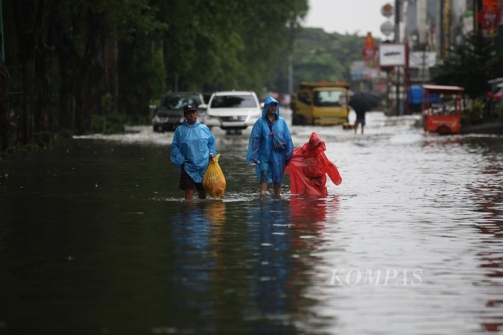 Ilustrasi. Warga berusaha melalui genangan banjir di Kelapa Gading, Jakarta Utara, Jumat (22/3/2024). Hujan yang turun semalaman menyebabkan banjir dan genangan di sejumlah tempat di Ibu Kota sejak dini hari. 
