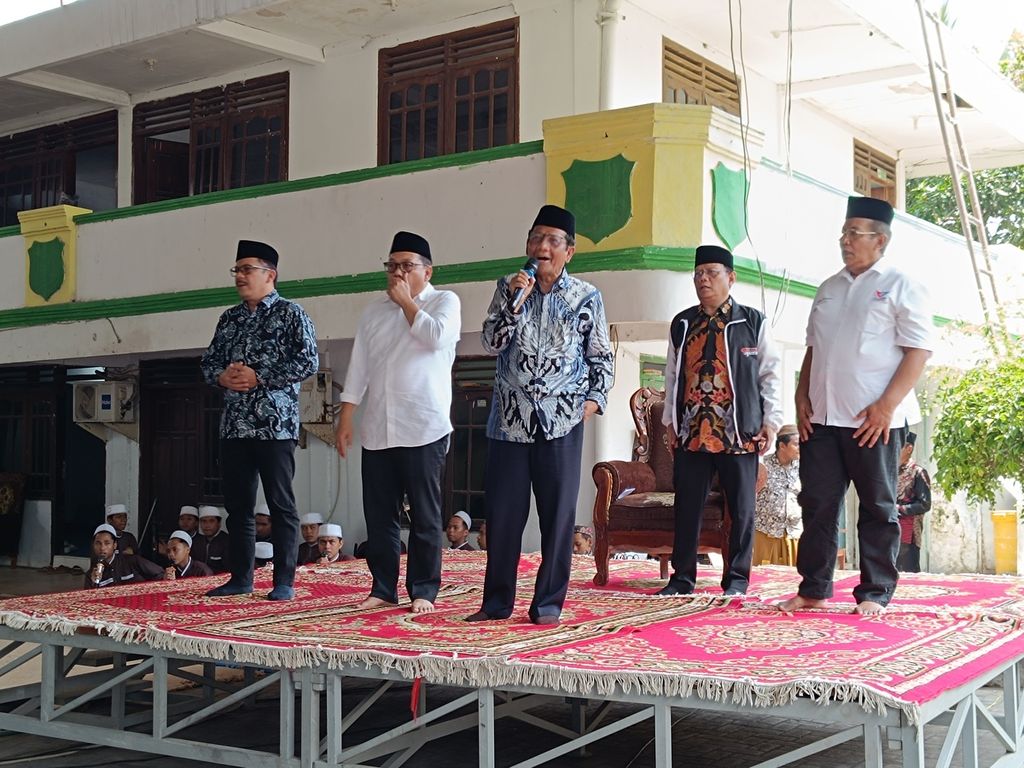 Menteri Koordinator Bidang Politik, Hukum, dan Keamanan Mahfud MD (tengah) menyanyikan selawat bersama dengan santri di Pondok Pesantren Al Khoziny, Sidoarjo, Jawa Timur, Kamis (28/12/2023). 