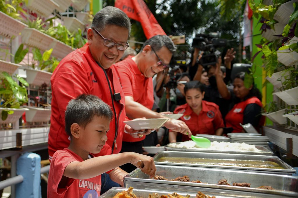 A child picks up food at the Dinner for 10,000 DKI Jakarta Residents on Jalan Baladewa, Johar Baru, Central Jakarta, Sunday (8/1/2023). The event was to welcome the 50th anniversary of the Indonesian Democratic Party of Struggle (PDIP) by distributing food to thousands of residents.