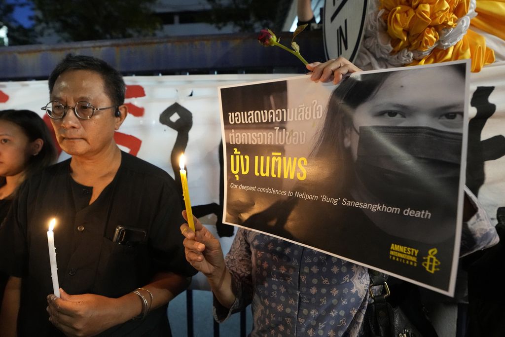 Para aktivis Thailand menyalakan lilin dan membawa poster wajah Netiporn Sanesangkhom, aktivis pejuang reformasi monarki yang meninggal saat menjalani tahanan, dalam acara di Bangkok, Thailand, Selasa (14/5/2024). 