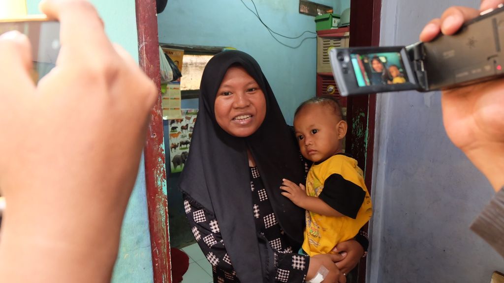 Nur Hasanah bersama anak keduanya di rumah mereka di Kelurahan Pademangan Timur, Kecamatan Pademangan, Jakarta Utara, Kamis (10/10/2019). Sebelumnya, sebanyak 21 anak berusia di bawah lima tahun atau balita mengalami muntah dan beberapa disertai diare, Rabu (9/10/2019), seusai mengonsumsi makanan dari kegiatan posyandu di RW 010 Pademangan Timur. Nur dan dua anaknya termasuk korban.
