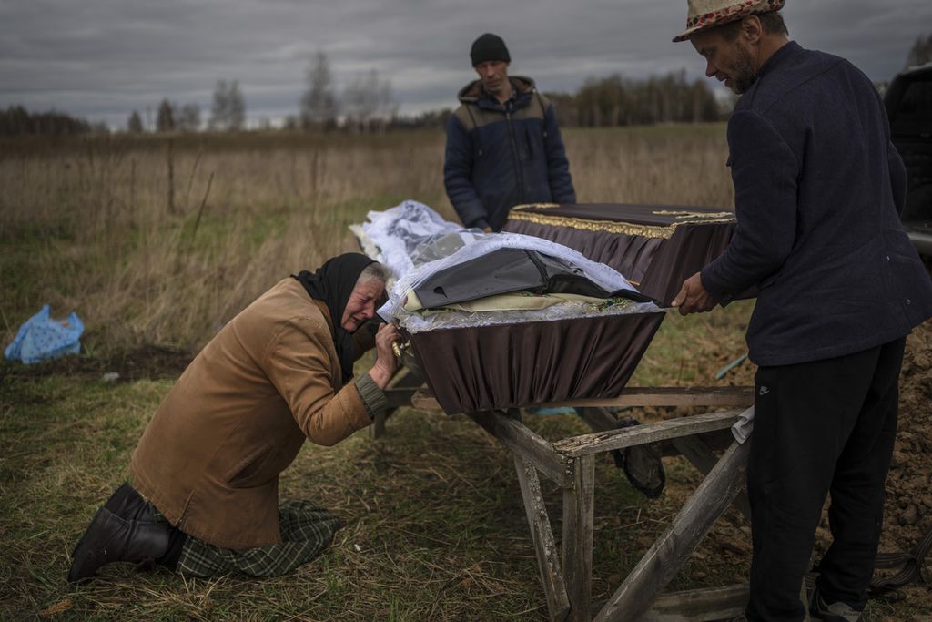 Nadiya Trubchaninova (70) menangis saat memegang peti jenazah putranya, Vadym (48), yang tewas oleh tentara Rusia di Bucha pada 30 Maret 2022, dalam upacara pemakaman di Mykulychi, pinggiran Kyiv, Ukraina, 16 April 2022. 