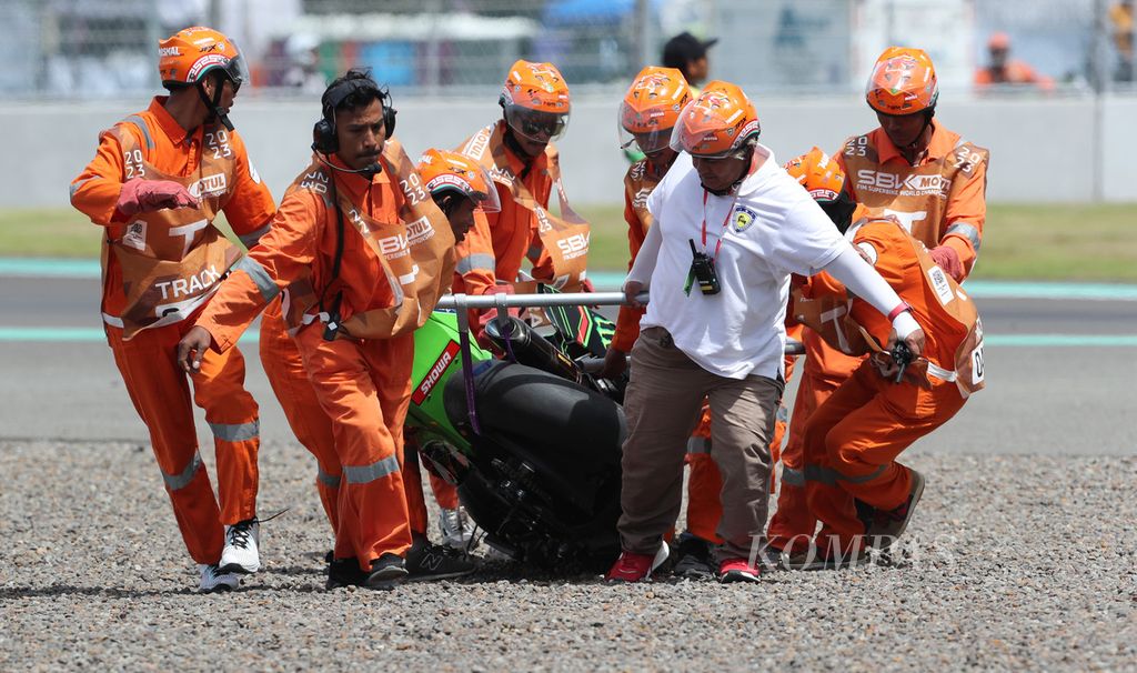 Petugas mengevakuasi motor pebalap Kawasaki Racing, Alex Lowes, yang patah jadi dua setelah kecelakaan pada sesi balapan <i>superpole</i> WSBK Mandalika 2023 di Sirkuit Internasional Jalan Raya Pertamina Mandalika di Kuta, Pujut, Lombok Tengah, Nusa Tenggara Barat, Minggu (5/3/3023). 