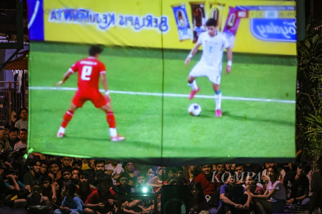 Warga menonton pertandingan Indonesia melawan Irak dalam Piala Asia U-23 di kawasan Grogol Utara, Jakarta Selatan, Jumat (3/5/2024).  Indonesia akan bertanding melawan Guinea dalam laga play-off antarzona Kualifikasi Olimpiade Paris, Kamis (9/5/2024) di Clairefontaine, Perancis.