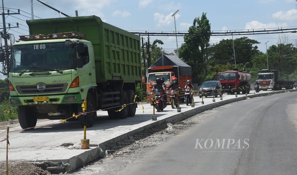 Kendaraan antre melewati proyek perbaikan jalan By Pass di Kota Mojokerto, Jawa Timur, Selasa (4/4/2023). Jalan tersebut merupakan jalan nasional yang menghubungkan Surabaya-Mojokerto. Untuk menghindari kepadatan kendaraan selain pengalihan jalur melalui dalam Kota Mojokerto, dilakukan rekayasa lalu lintas sistem buka tutup melewati jalan yang belum dicor atau bagian jalan yang selesai dicor. Jalur tersebut menjadi jalur penting pada musim mudik Lebaran. 