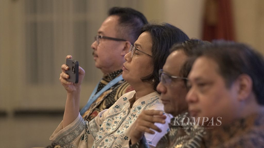 Menteri Keuangan Sri Mulyani Indrawati mengabadikan dengan ponselnya di sela-sela diskusi panel Kompas100 CEO Forum <i>powered by</i> East Ventures di Istana Negara, Jumat (2/12/2022). 