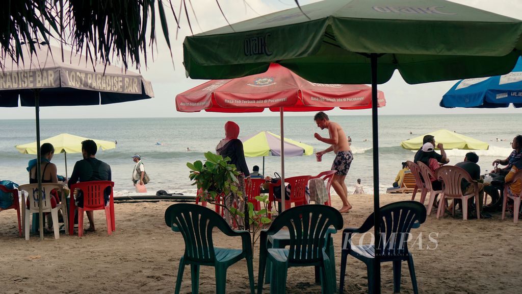 Wisatawan menikmati suasana Pantai Kuta di Kabupaten Badung, Bali, Minggu (3/7/2022). Jumlah pelaku perjalanan domestik dan wisatawan asing terus meningkat setelah Lebaran 2022 hingga kini. 