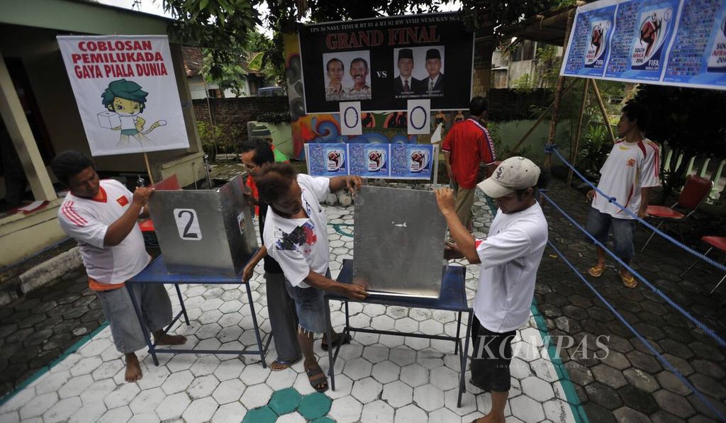 Warga bergotong royong membangun tempat pemungutan suara (TPS) pemilihan wali kota dengan nuansa sepak bola dan Piala Dunia di TPS 36 Nayu Timur, Kelurahan Nusukan, Kota Surakarta, Minggu (25/4/2010). 