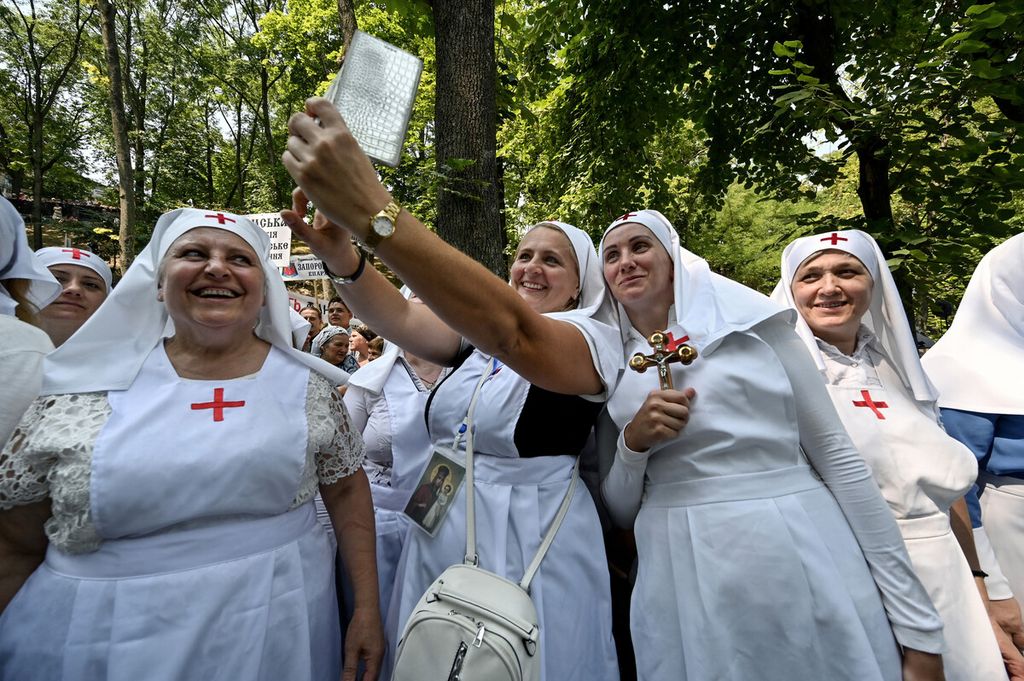 Para biarawati Kristen Ortodoks berswafoto saat mereka turut dalam kebaktian dan prosesi keagamaan selama perayaan 1.033 tahun Kristenisasi Kekaisaran Kievan Rus (Rus Kiev) di ibukota Ukraina Kiev, Rabu (27/7/2021).