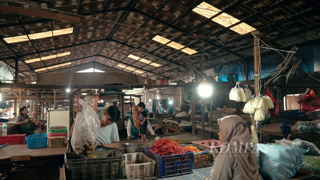 Pedagang mempersiapkan sayuran yang akan dijual malam hingga pagi hari di Pasar Cakung, Jakarta Timur, Senin (11/7/2022). 