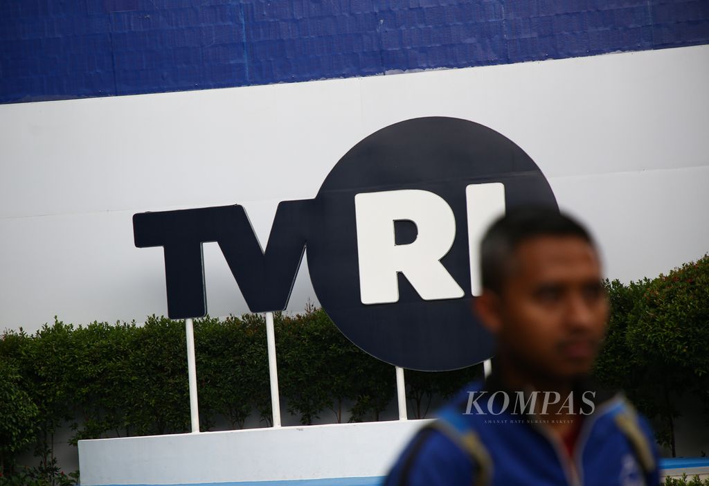 Karyawan melintas di depan Logo TVRI di kompleks Lembaga Penyiaran Publik Televisi Republik Indonesia (TVRI) di Senayan, Jakarta Pusat, Sabtu (18/1/2020). 
