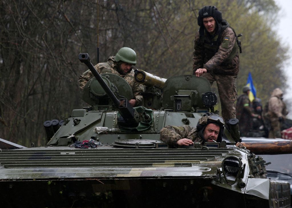 Tentara Ukraina menaiki kendaraan tempur di dekat Distrik Izyum, Kharkiv, Senin (18/4/2022). Militer Ukraina berjibaku menghadapi fase II agresi militer Rusia di negara ini.