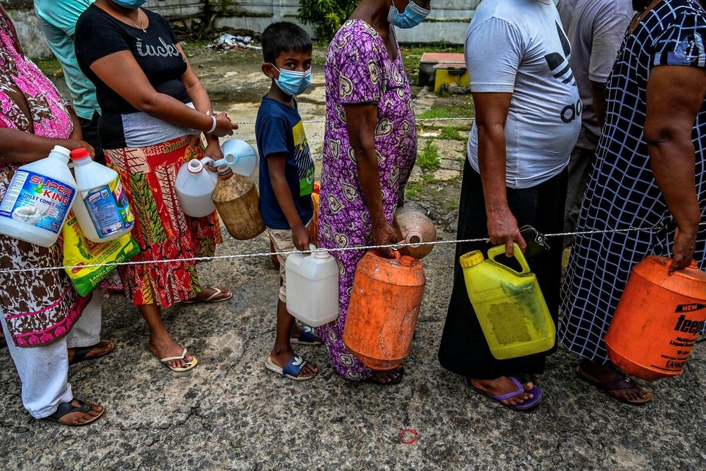 Seorang anak membawa jerigen berada di tengah antrean warga yang akan membeli minyak tanah di Kolombo, Sri Lanka, Kamis (4/11/2021). AFP/ISHARA S. KODIKARA