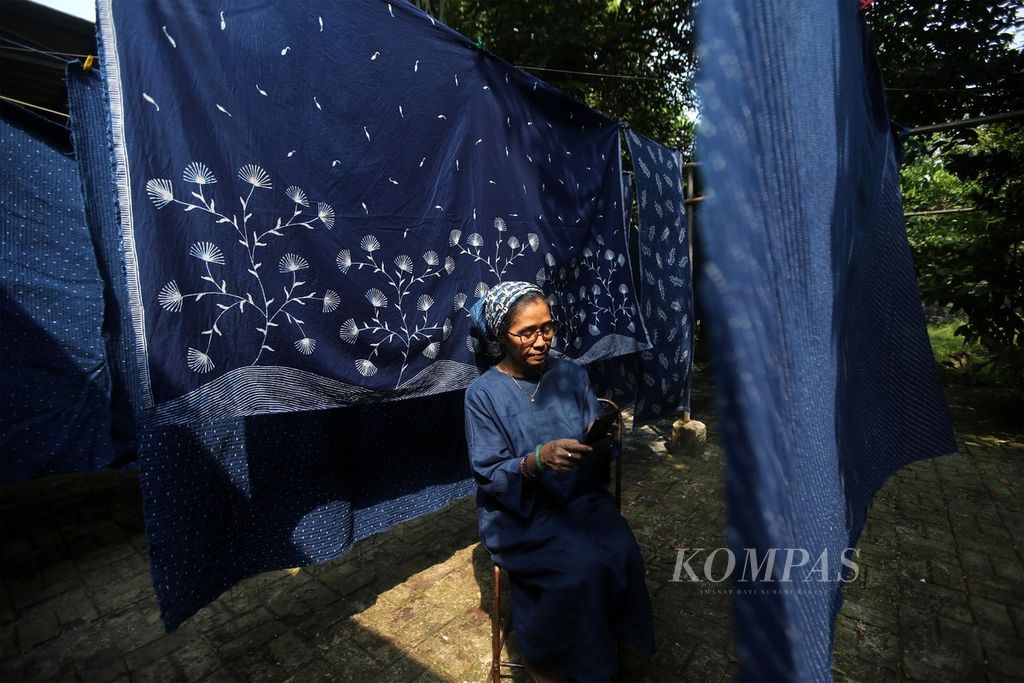 Rini, pemilik UMKM batik Kanagoods, menunjukkan mengecek dagangannya yang dipasarkan melalui media sosial dan lokapasar Tokopedia di Pamulang, Tangerang Selatan, Banten, Senin, (27/7/2020). 