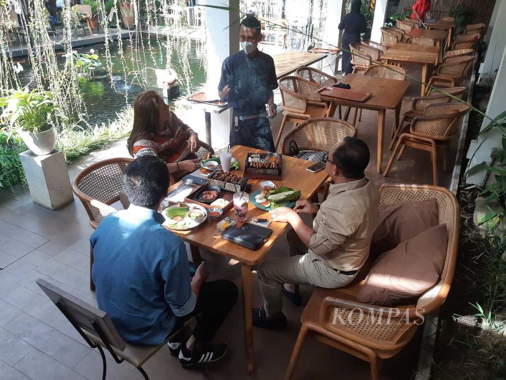 Pramusaji melayani konsumen Kedai Nyonya Rumah di Bandung, Jawa Barat, Jumat (20/5/2022).