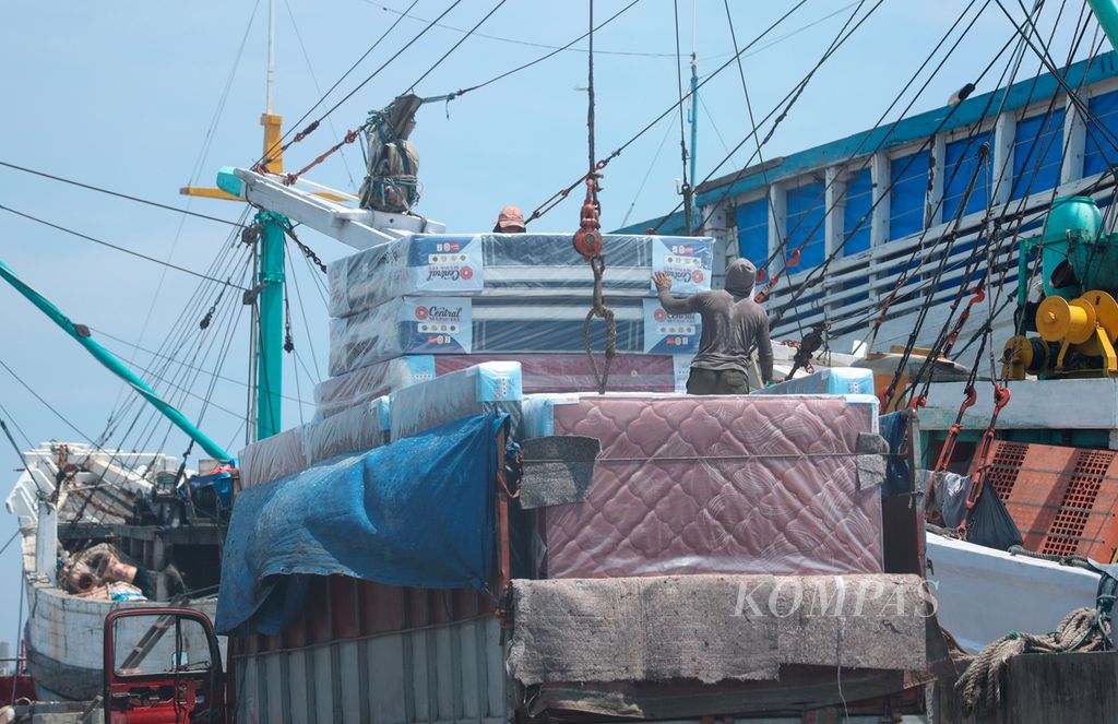 Pekerja memindahkan muatan dari sebuah truk ke atas kapal di kawasan Pelabuhan Tanjung Emas, Kota Semarang, Jawa Tengah, Jumat (24/3/2023). Pelayaran rakyat menjadi tulang punggung perdagangan dan distribusi barang serta jasa antarpulau. 