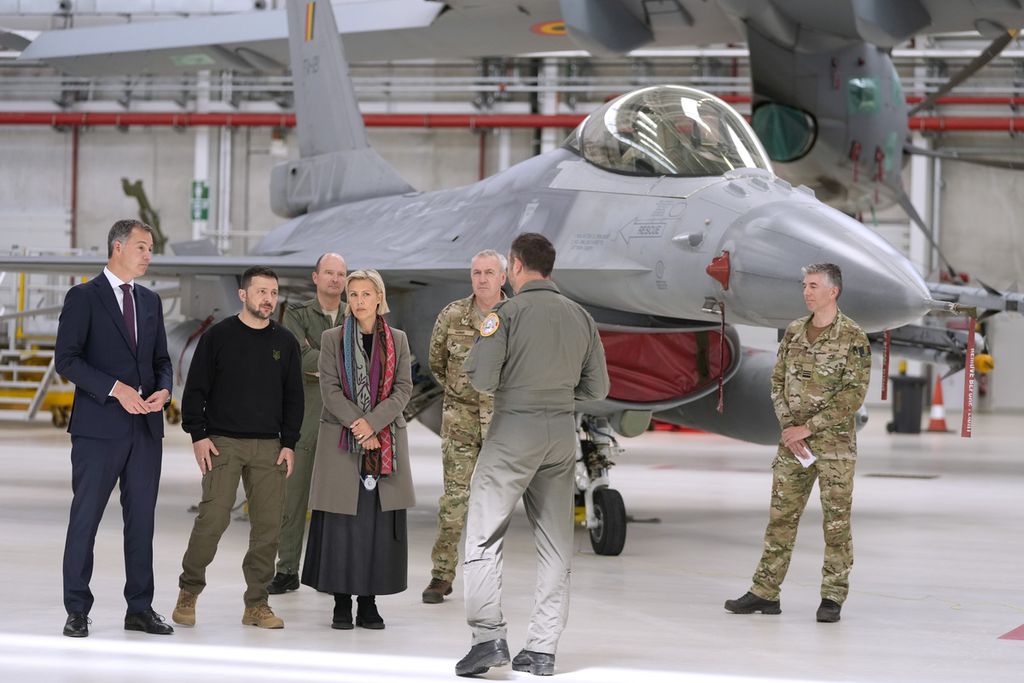 Dari kiri, Perdana Menteri Belgia Alexander De Croo, Presiden Ukraina Volodymyr Zelenskyy, dan Menteri Pertahanan Belgia Ludivine Dedonder saat mengikuti taklimat tentang F-16 di Pangkalan Melsbroek, Brussels, Selasa (28/5/2024). 