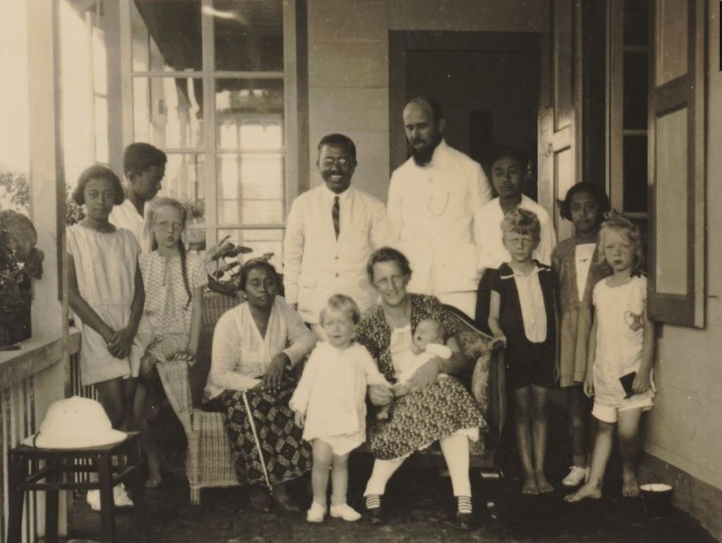 Keluarga Eropa berfoto di beranda dengan keluarga bumiputra, tamu mereka sekitar tahun 1935 (sumber: KITLV Leiden).