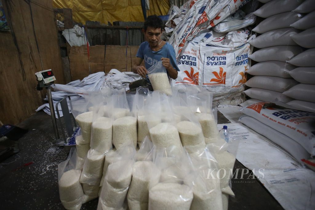 Pedagang mengemas beras ke dalam plastik ukuran 2,5 kilogram di Pasar Induk Beras Cipinang, Jakarta Timur, Jumat (16/2/2024).