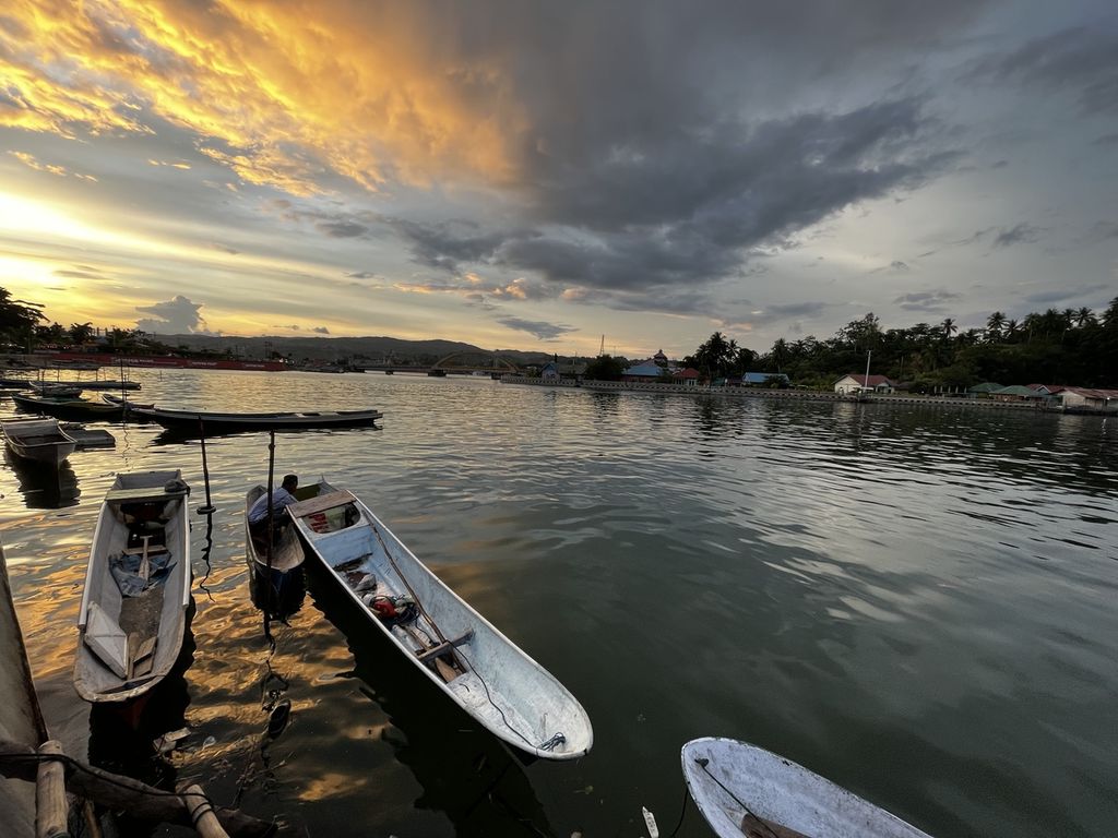 Rusman (49), nelayan kecil di Kendari, membersihkan bodi (perahu kecil) yang digunakan mencari cumi sehari-hari, di Petoaha, Kendari, Sulawesi Tenggara, Senin (20/6/2022). Perubahan iklim yang semakin nyata membuat hasil tangkapannya semakin berkurang dari waktu ke waktu. Ayah lima anak ini juga harus melaut lebih jauh meski hanya bisa menghasilkan Rp 100.000 per hari.