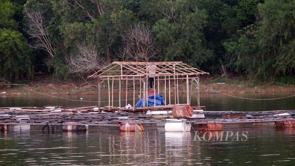 Seorang warga membangun rumah jaga untuk budidaya ikan dalam keramba jaring apung di Waduk Riam Kanan, Desa Benua Riam, Kecamatan Aranio, Kabupaten Banjar, Kalimantan Selatan, Sabtu (28/5/2022).