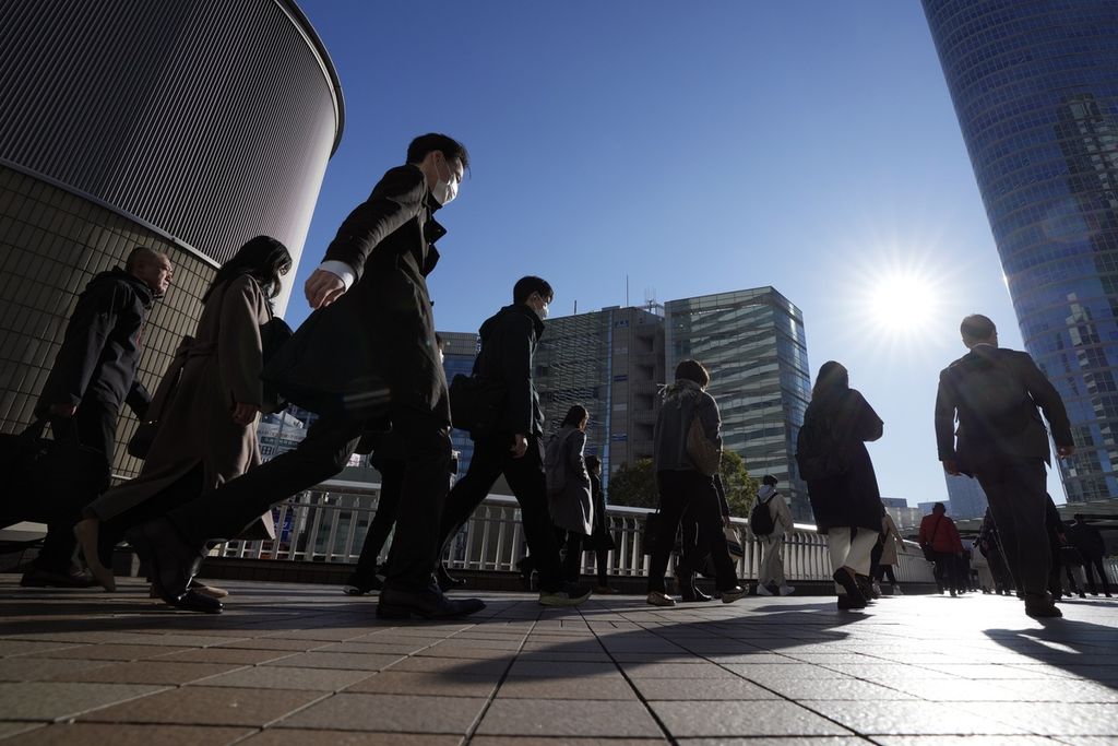 Pekerja pengguna kereta api berjalan di sekitar Stasiun Shinagawa, Tokyo, Jepang, Rabu (14/2/2024). Pemerintah berencana untuk menaikkan upah pekerja dan buruh guna mendorong kenaikan konsumsi. 