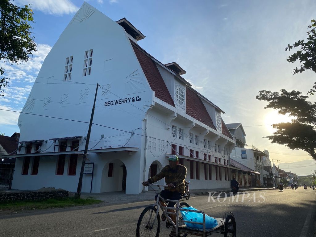 Seorang warga dengan sepeda pembawa barang melintas di depan Gedung Geo Wehry & CO di Kawasan Kota Tua Padang, Kota Padang, Sumatera Barat, Jumat (16/6/2023) pagi. Gedung tersebut adalah salah satu bangunan bersejarah peninggalan zaman kolonial Belanda dan saat ini menjadi bangunan cagar budaya yang dilindungi.