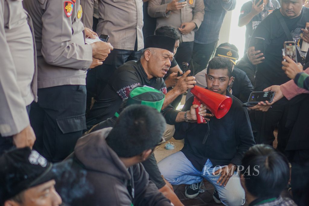 Wakil Ketua DPRD Balikpapan Budiono menelepon Ketua DPRD Balikpapan Abdulloh saat di depan mahasiswa yang berunjuk rasa di depan kantor DPRD Kota Balikpapan, Kalimantan Timur, Jumat (23/8/2024). Mereka menuntut agar pemerintah dan DPR menjalankan putusan MK soal pemilu.