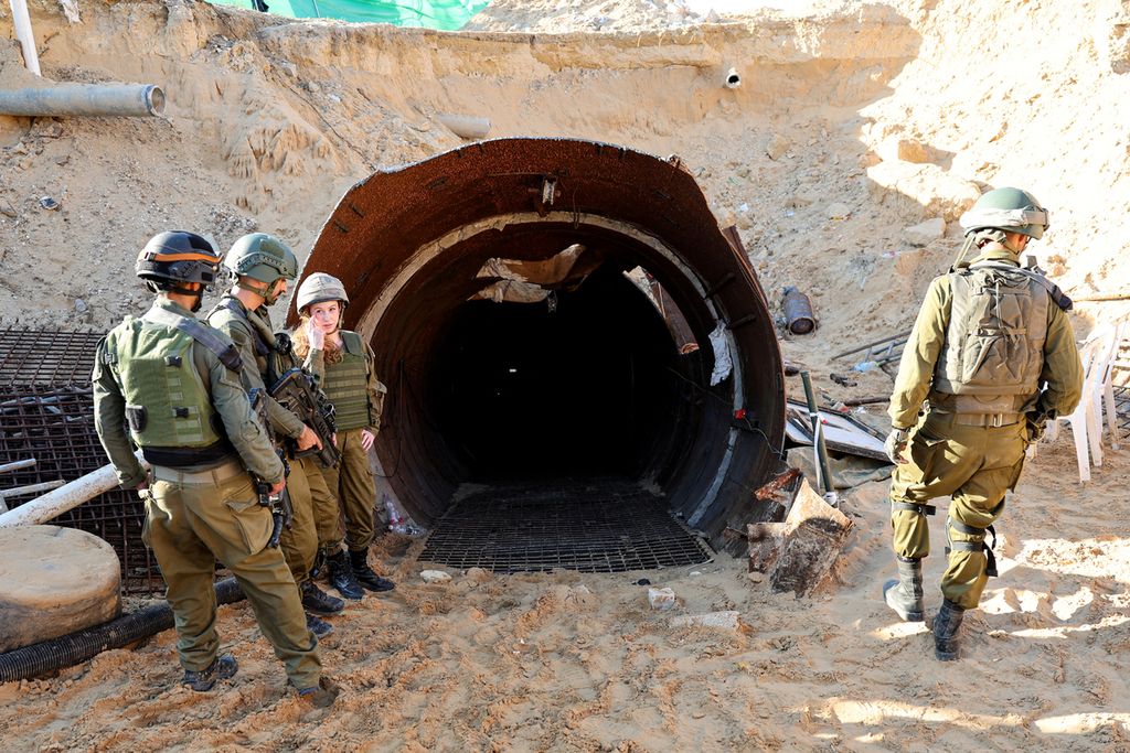 Sejumlah tentara Israel berdiri di depan pintu masuk terowongan milik Hamas di Gaza. Terowongan itu disebutkan digunakan Hamas saat menyerang Israel, tepatnya di pintu pelintasan Erez pada 7 Oktober lalu. Foto yang diambil saat kunjungan media yang diatur oleh Angkatan Bersenjata Israel pada Jumat (15/12/2023).