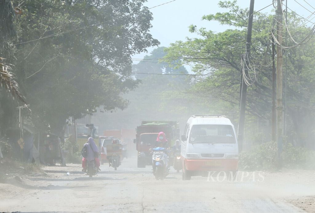 Polusi debu menjadi pemandangan sehari-hari di Jalan Raya Sukamulya, Rumpin, Bogor, Jawa Barat, Kamis (18/7/2019). Polusi debu itu berasal dari ratusan truk pengangkut material yang setiap hari melintasi jalan di kawasan Bogor barat ini. Kondisi ini rawan mengganggu kesehatan warga sekitar.