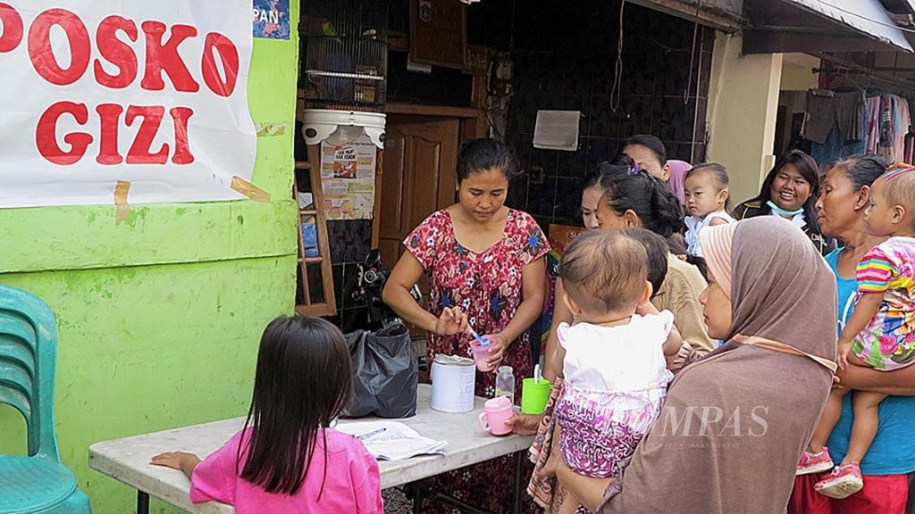 Beberapa ibu di RW 001 Kelurahan Kalibaru, Kecamatan Cilincing, Jakarta Utara, Rabu (22/2) mengantre susu untuk anaknya yang dibagikan langsung oleh relawan Foodbank of Indonesia (FOI) dan kader kesehatan di RW setempat.