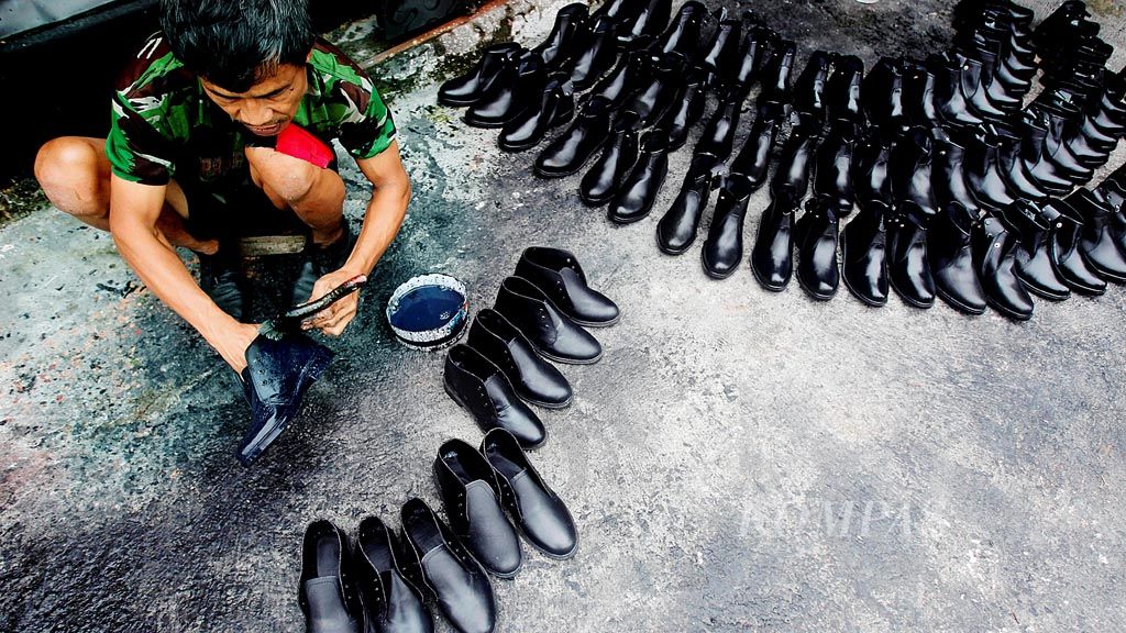  Ajo (41)  menyelesaikan sepatu yang diproduksinya di Kampung Laksana, Ciomas, Kabupaten Bogor, Jawa Barat, Selasa (26/6/2018). Produksi sepatu dari industri kecil ini dijual ke sejumlah wilayah di Jakarta, seperti Pasar Senen. Sepatu dijual dengan harga Rp 150.000 per pasang. 