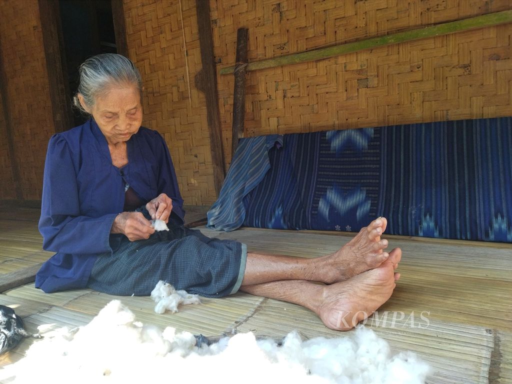 Warga Kampung Gajebo mengeluarkan biji kapas, Selasa (19/7/2022). Kapas itu akan dipintal menjadi benang untuk menenun.